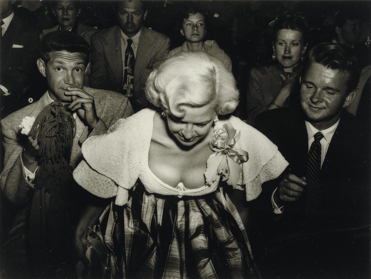 WEEGEE [ARTHUR FELLIG] (1899-1968) Buxom blonde woman in open collar dress.